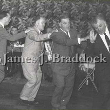 Jim leads the dance as the band plays behind them.